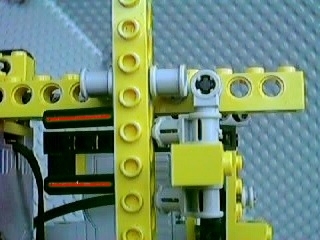 The tops of the legs (almost) aligned, and two #3 cross axles being inserted from the left into the vertical yellow beam